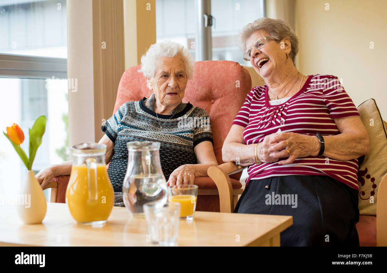 Ältere Damen genießen einen Witz in einem Pflegeheim Stockfoto