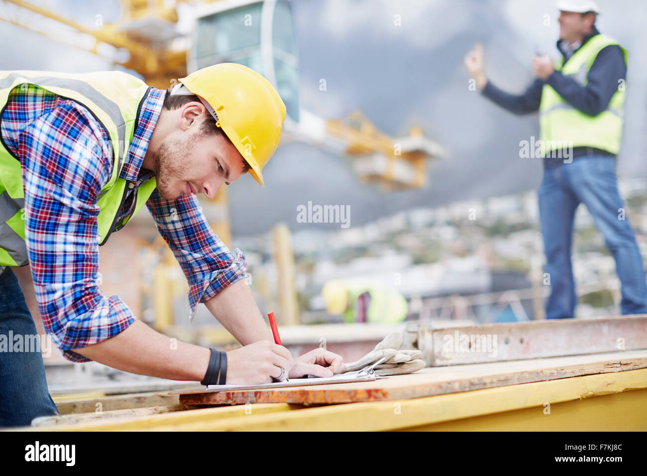 Bauarbeiter schreiben in Zwischenablage auf Baustelle Stockfoto