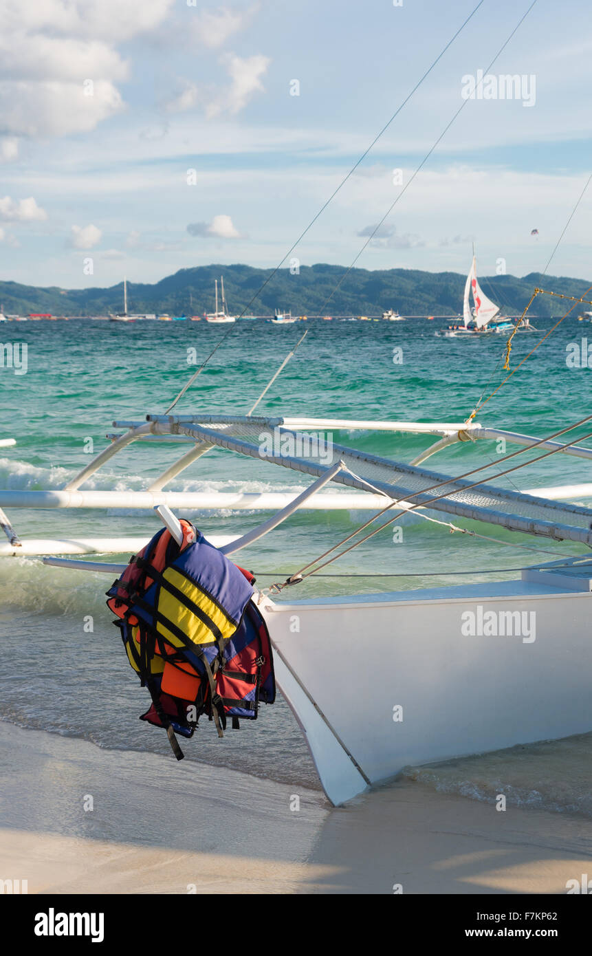 Rettungswesten, hängen auf einem Boot an einem tropischen Strand Stockfoto