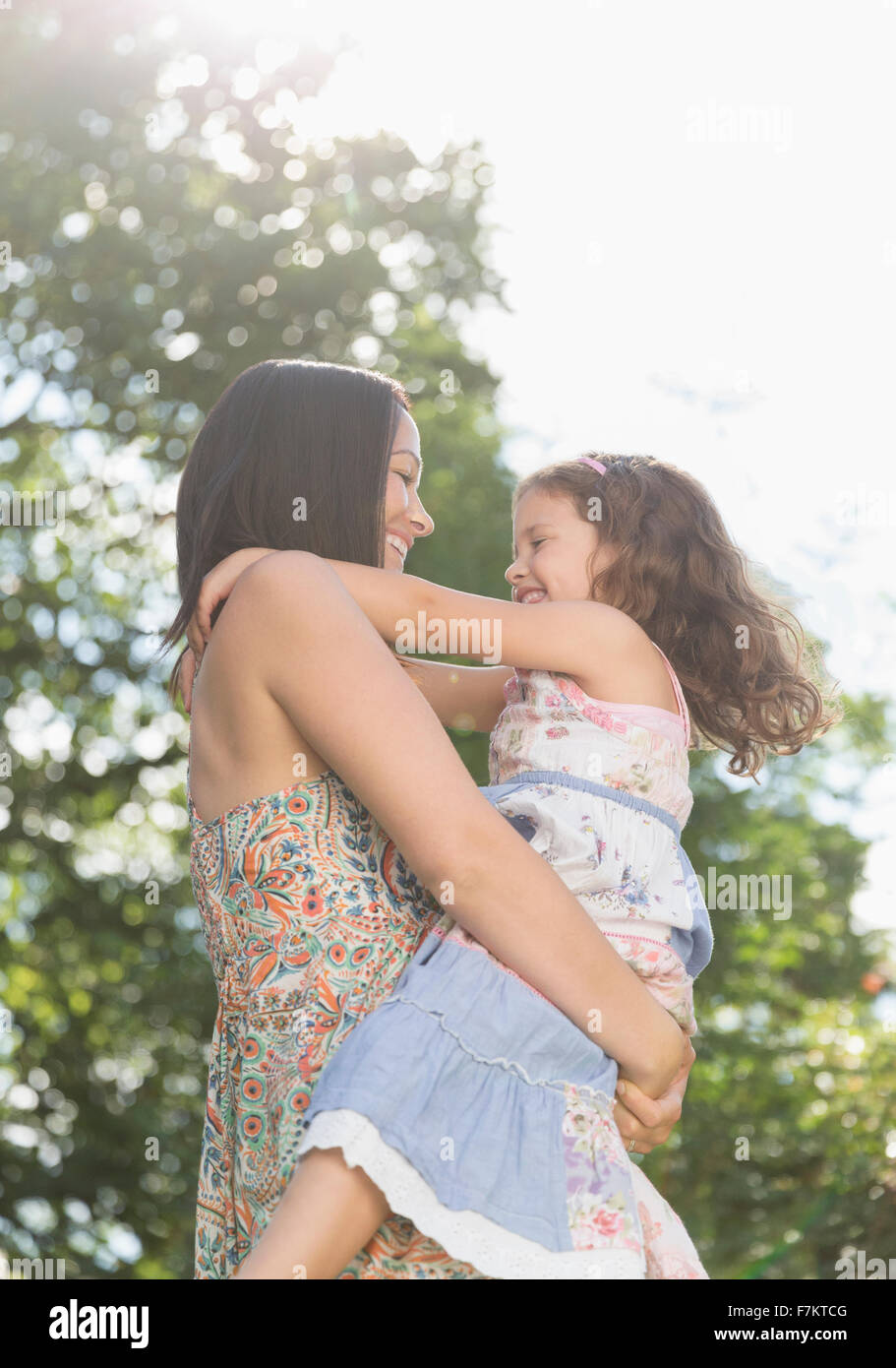 Liebevolle Mutter halten und umarmen Tochter im freien Stockfoto