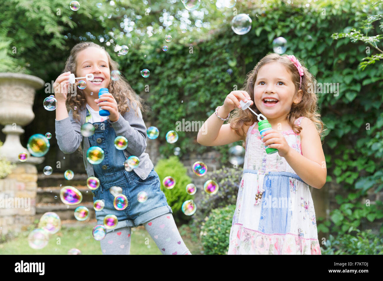 Unbeschwerten Mädchen bläst Seifenblasen im Hinterhof Stockfoto