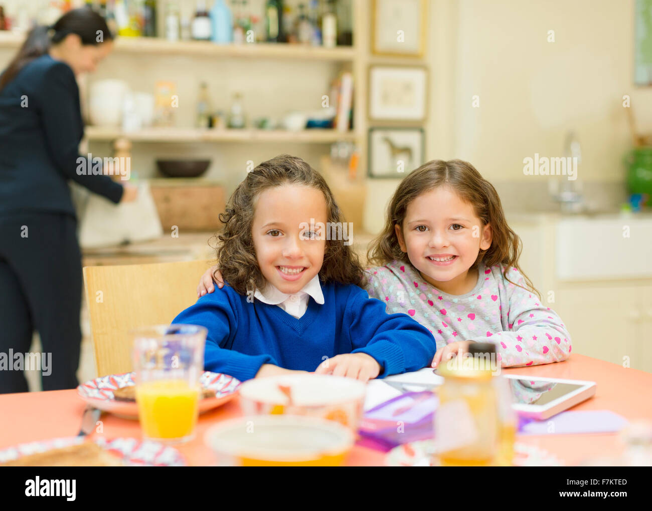 Porträt, Lächeln Schwestern am Frühstückstisch Stockfoto