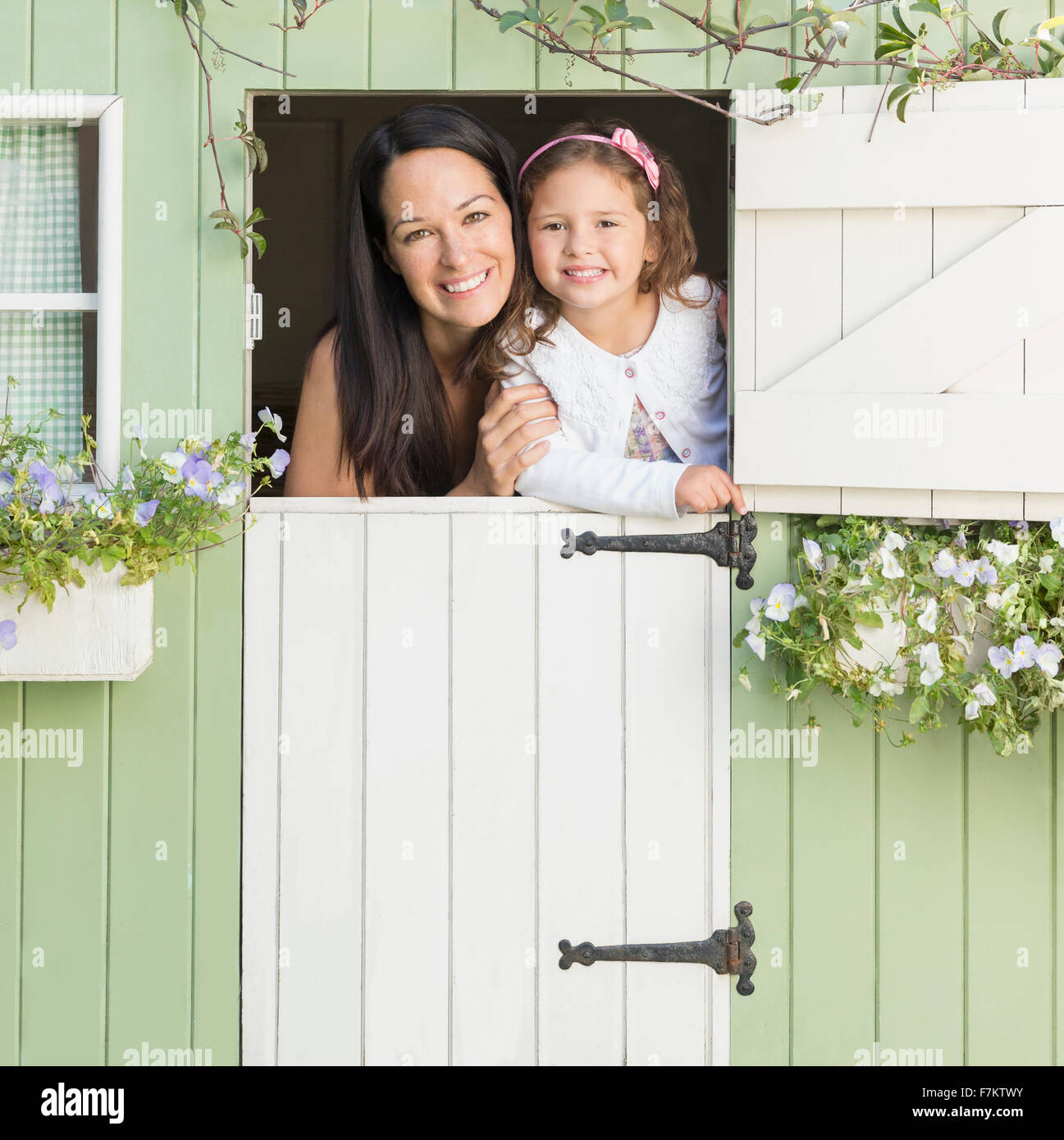 Porträt, Lächeln, Mutter und Tochter im Spielhaus-Fenster Stockfoto