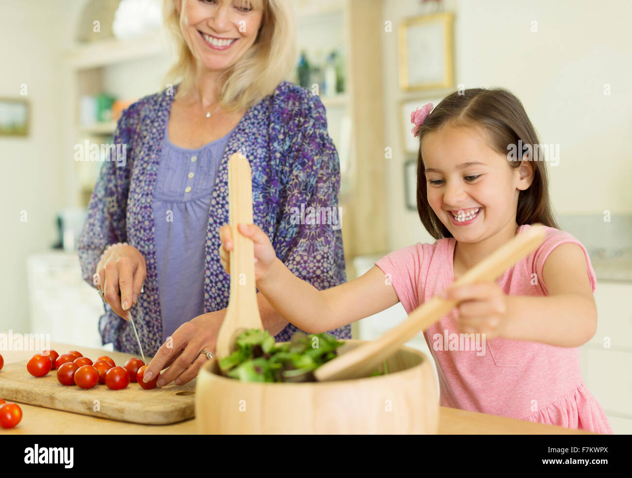 Großmutter und Enkelin bereitet Salat in Küche Stockfoto