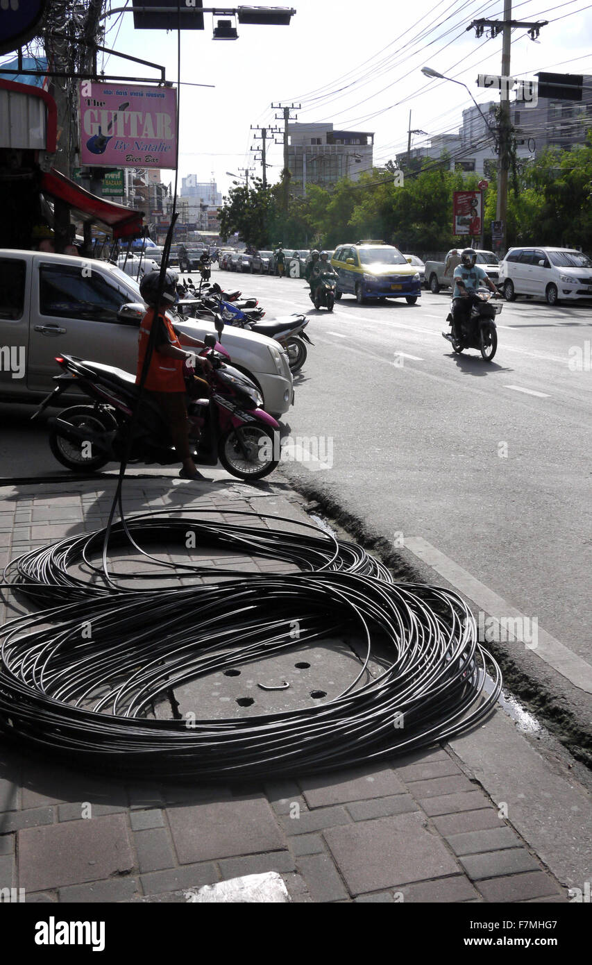 Elektrische Leitungen Spiralkabel bis auf dem Bürgersteig/Gehsteig/am Straßenrand zu einem gefährlichen Hindernis in Pattaya Thailand Stockfoto
