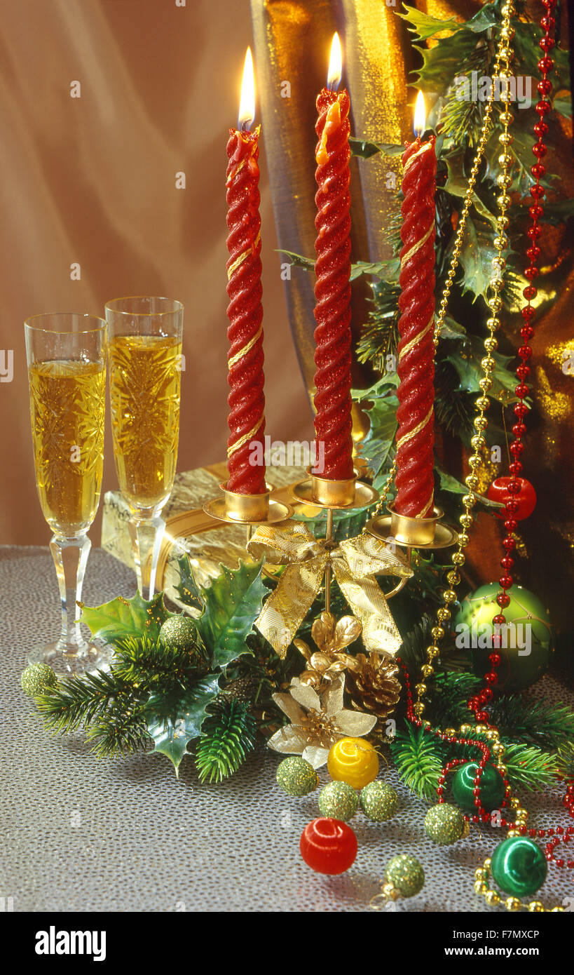 Festliches Silvester, Weihnachten Stilleben mit zwei Kristallgläser mit Wein und eine Kerze mit drei roten Kerzen. vertikale Stockfoto