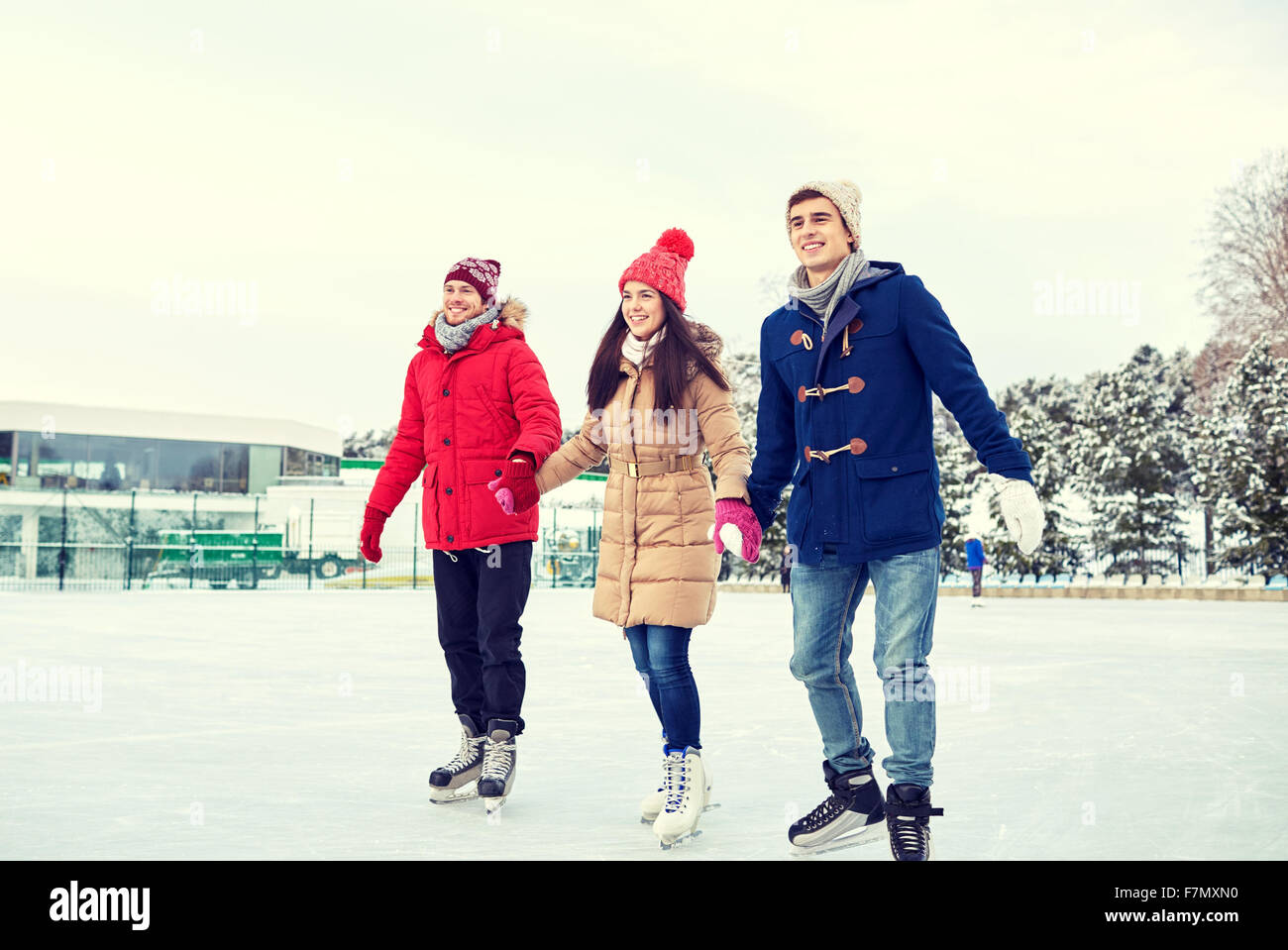 Glückliche Freunde Eislaufen am Eislaufplatz im freien Stockfoto