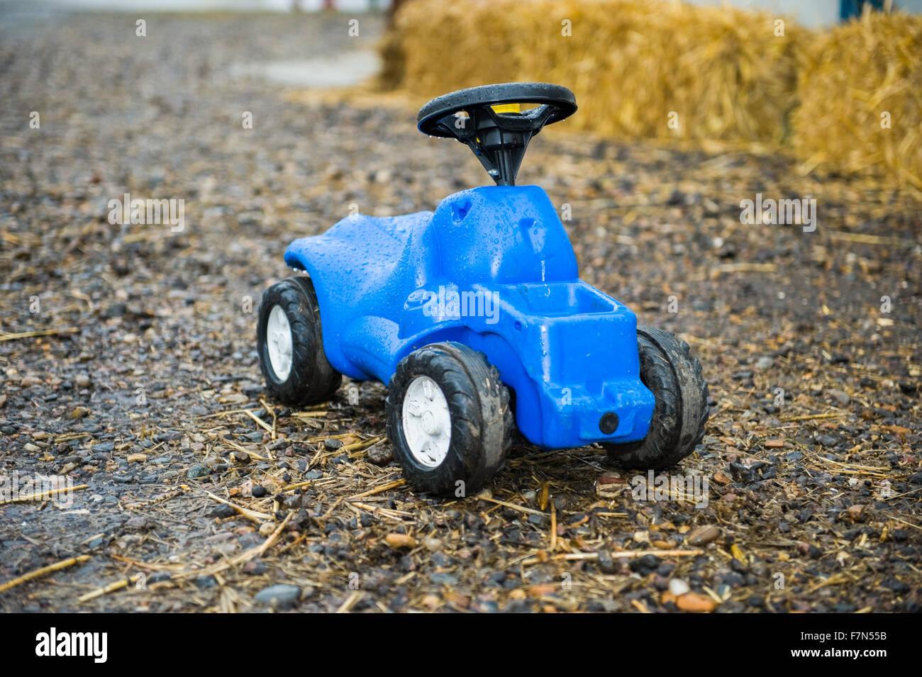 Kinder blau Spielzeug-Traktor draußen im Regen Stockfoto