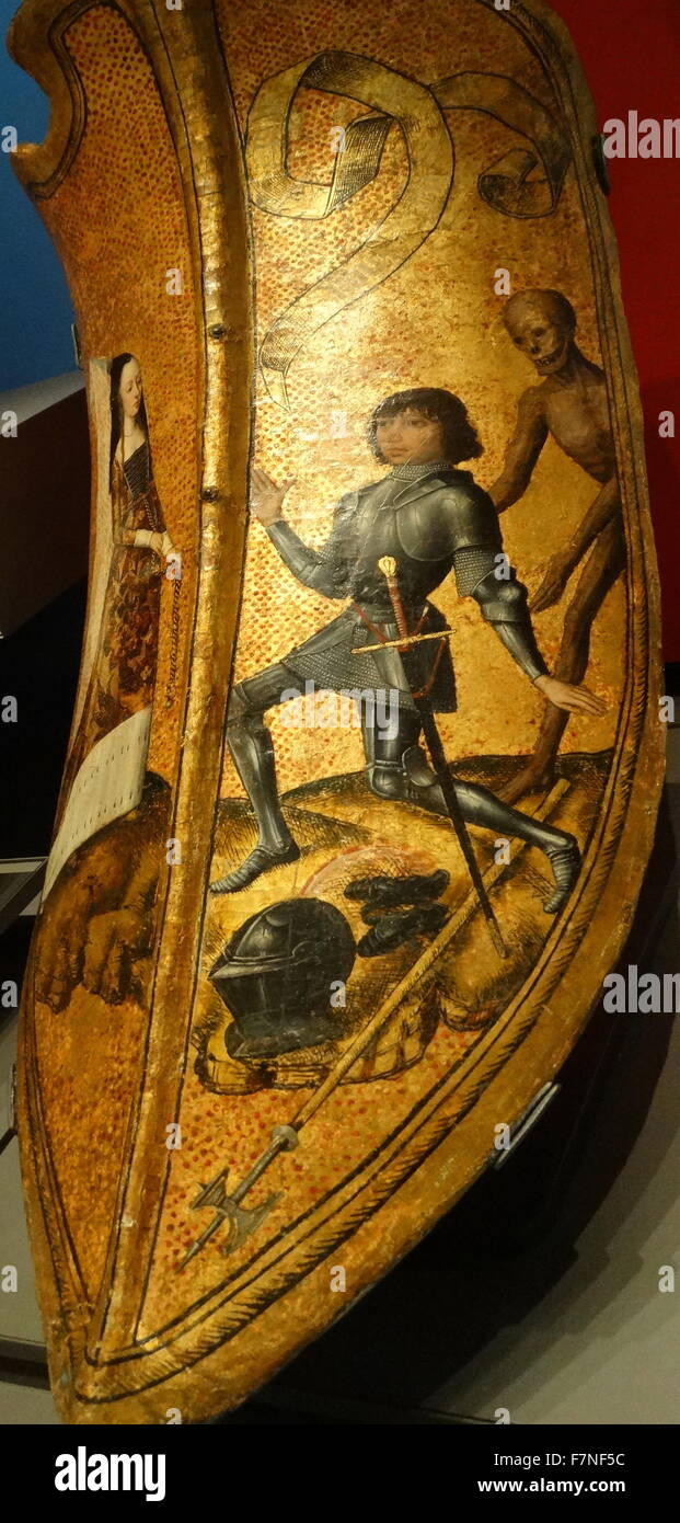 Französischen mittelalterlichen Schild (vielleicht ein Geschenk oder einen Preis in einem Turnier gewesen sein). Zeigt eine Dame trägt einen flämischen wies Kopfschmuck und ein junger Ritter kniend zu ihren Füßen. Der Tod lauert hinter ihm. Die Legende auf die Schriftrolle über seinem Kopf liest: "Vous Ou la Mort" ("Sie oder Tod"). Etwa 1475-1500 Flandern oder Burgund. Holz, Leder, Gips und Farbe Stockfoto