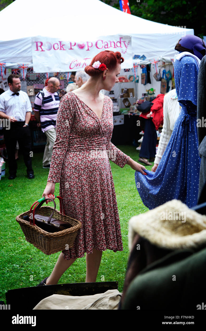 1940er Jahre Mode: Frau trägt eine Kleid der 1940er Jahre und shopping in einem Retro-Markt, England, UK. Stockfoto