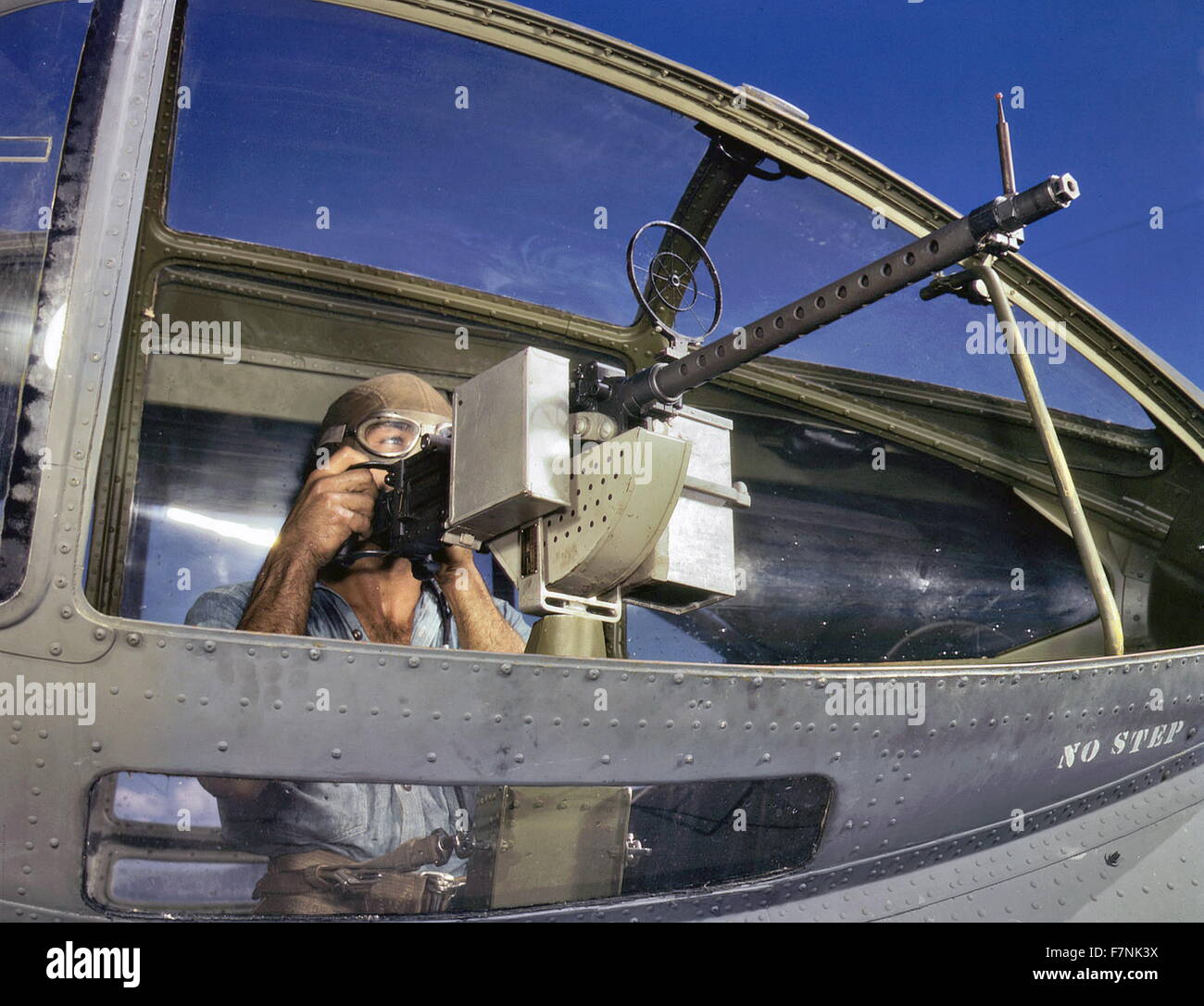 Zweiter Weltkrieg: US Navy Ordnance Mann mit einem Maschinengewehr Browning M1919 neben einem PBY Catalina Flugzeug Stockfoto