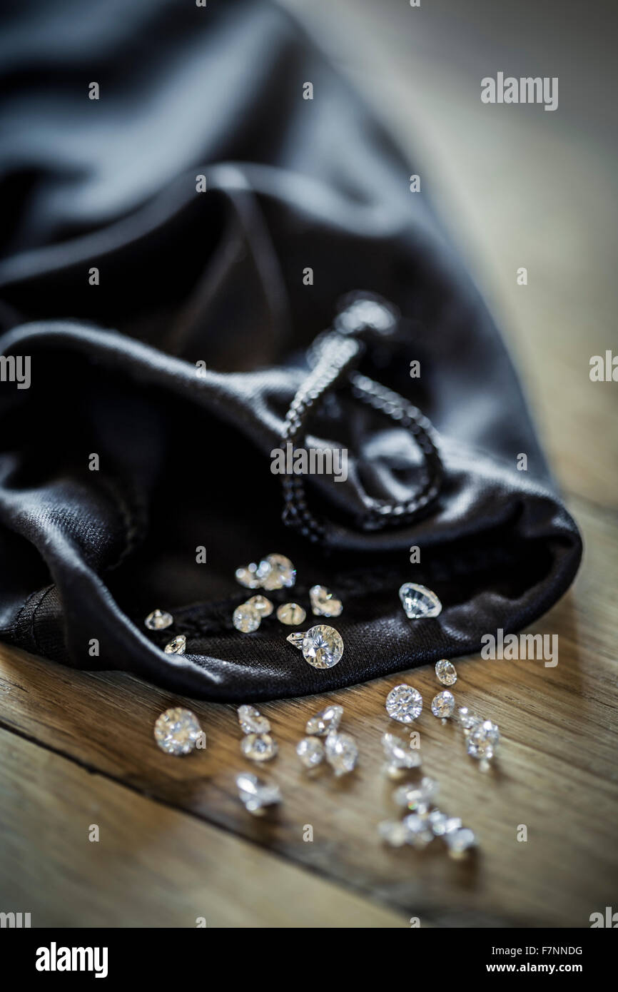 Diamanten von einem schwarzen Stoffbeutel verschütten. Stockfoto