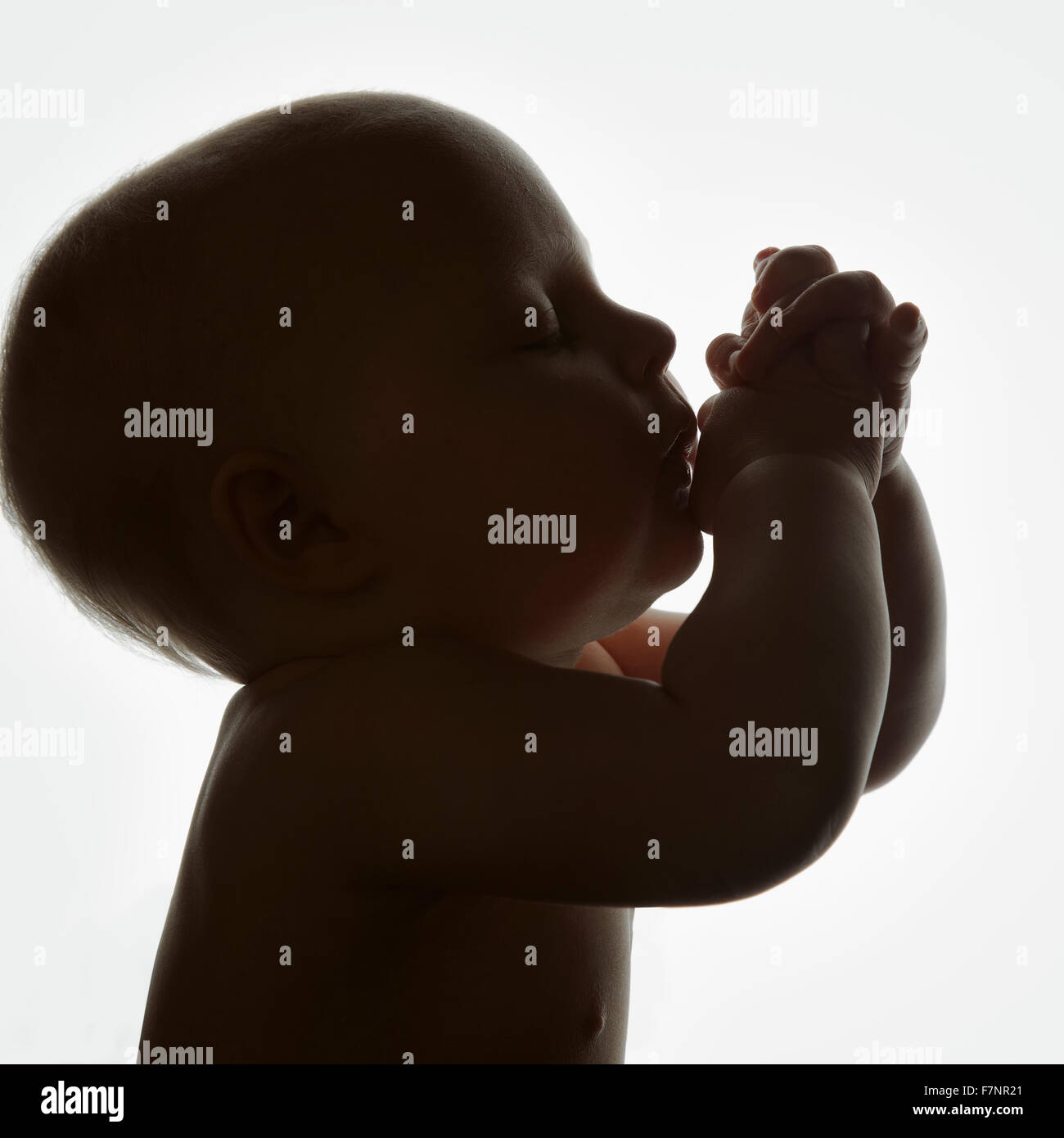 Silhouette eines Mädchens (8 Monate alten) Hände zum Gebet Falten Stockfoto