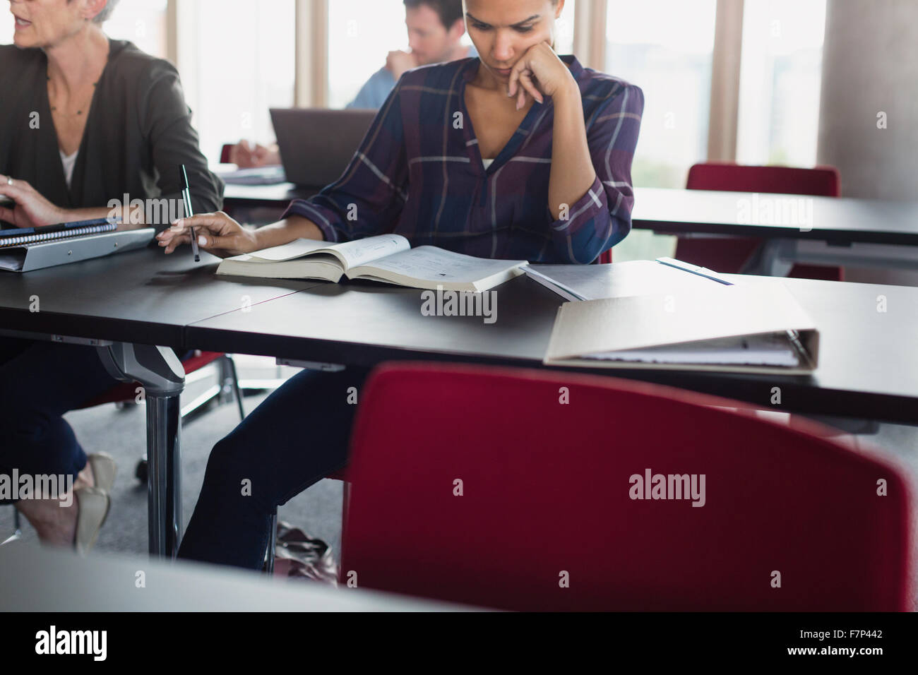 Konzentriert studieren mit Lehrbuch in Erwachsenenbildung Klasse Frau Stockfoto