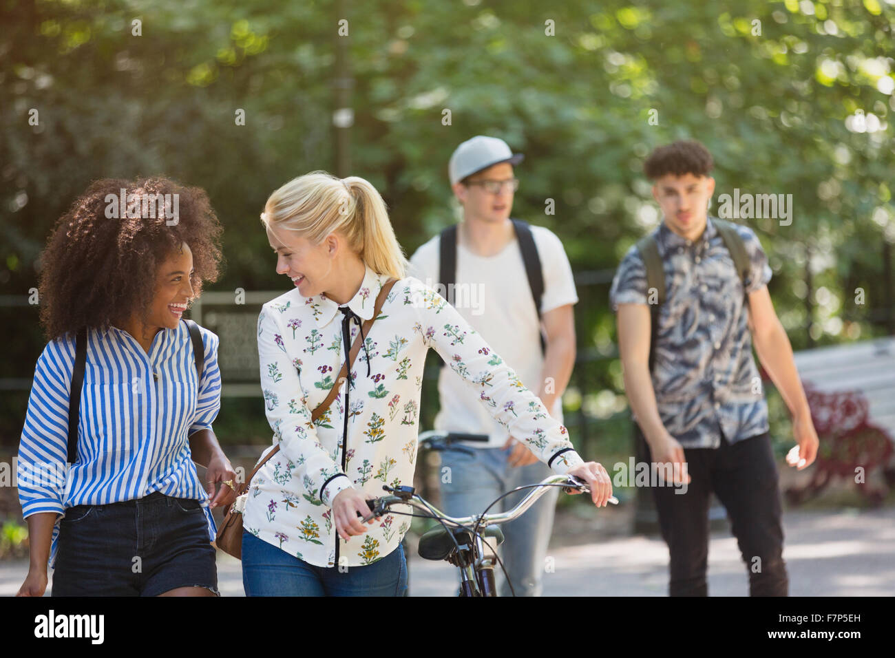 Freunde zu Fuß mit dem Fahrrad im park Stockfoto