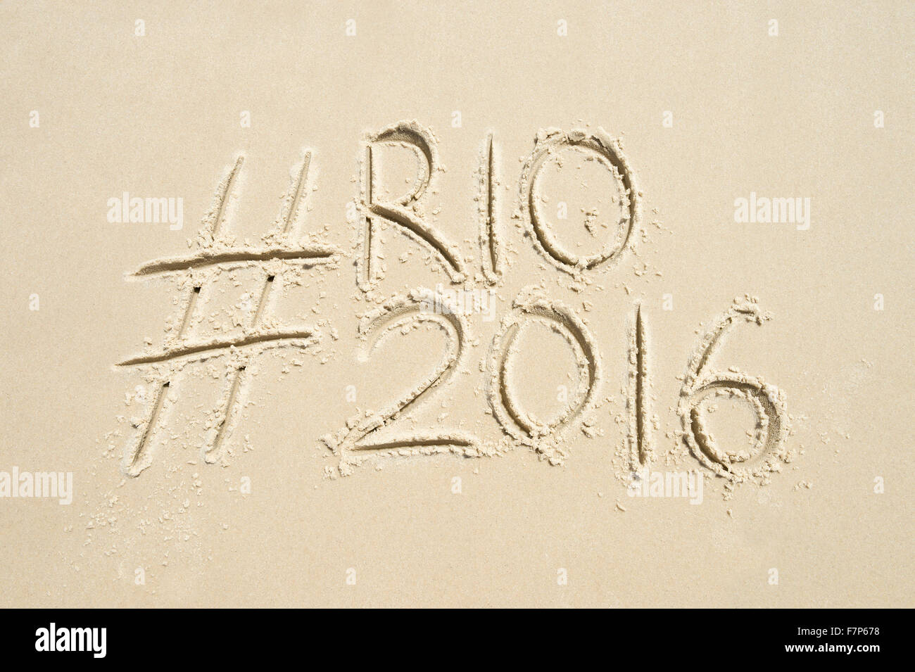 RIO DE JANEIRO, Brasilien - 10. November 2015: Handschriftliche Hashtag-social Media-Nachricht für die Rio 2016 Olympics in Sand geschrieben. Stockfoto