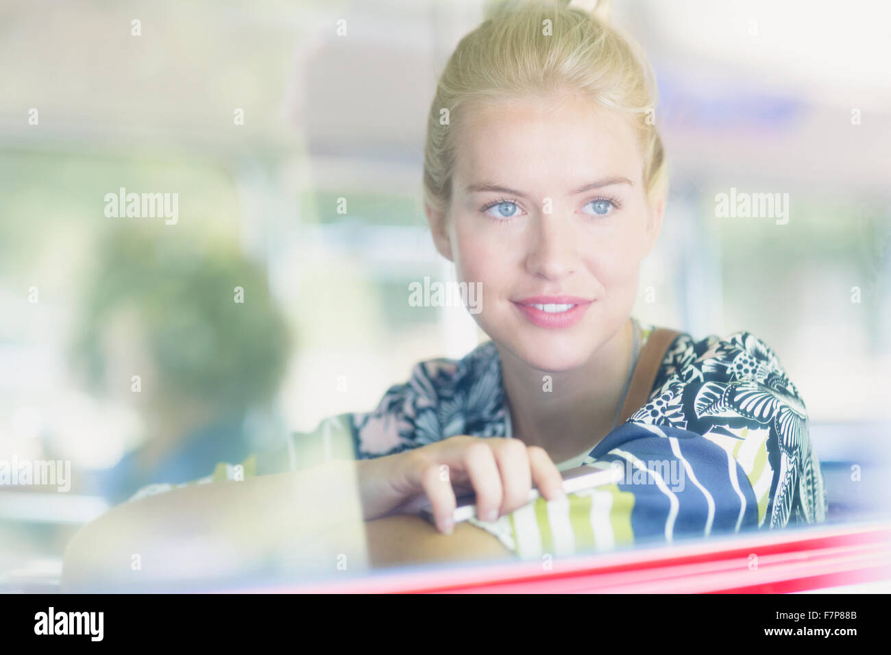 Blonde Frau schaut aus Fenster auf bus Stockfoto