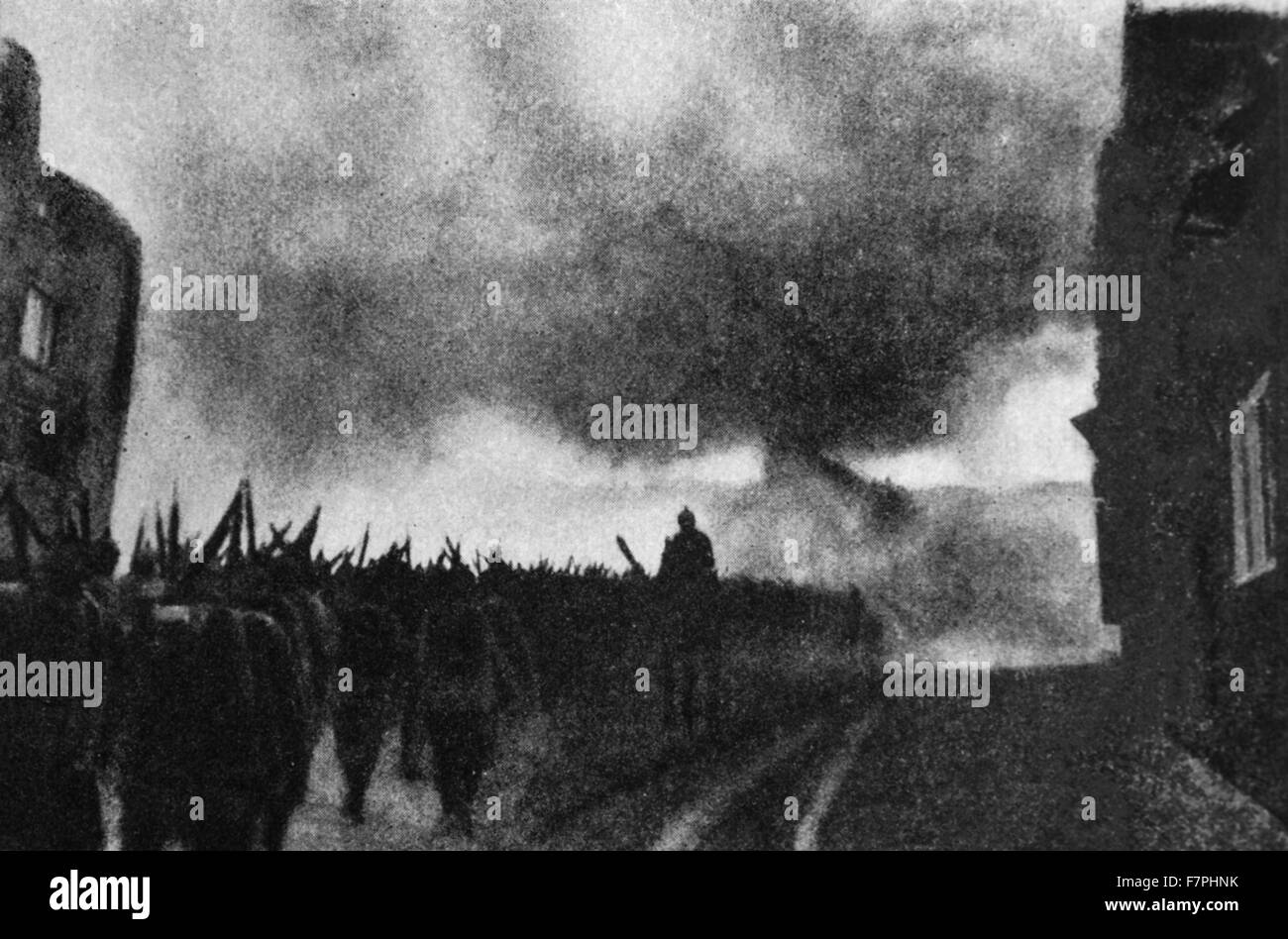 Deutsche Soldaten verlassen eine belgische Stadt in Flammen, wie sie an eine Schlacht-Front im ersten Weltkrieg eine 1914 marschieren Stockfoto