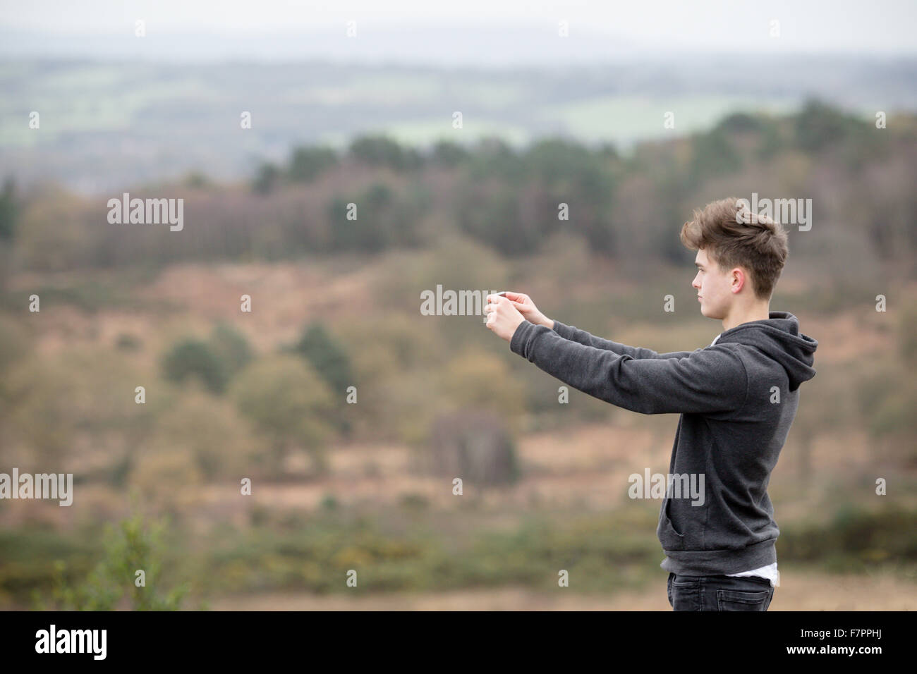 Teenager, die Aufnahme eines Fotos mit seinem Handy Stockfoto