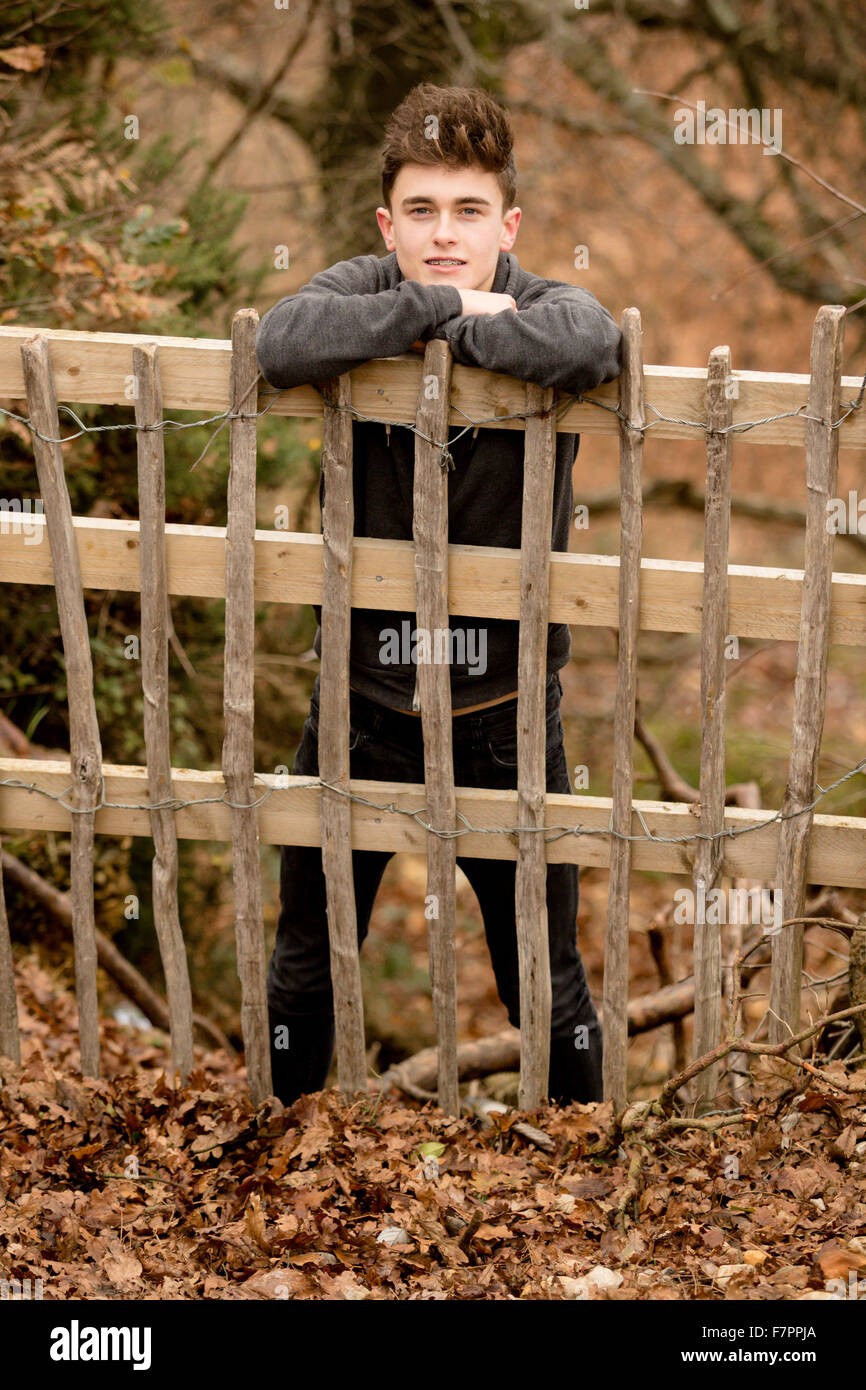 Teenager an einen Zaun gelehnt Stockfoto