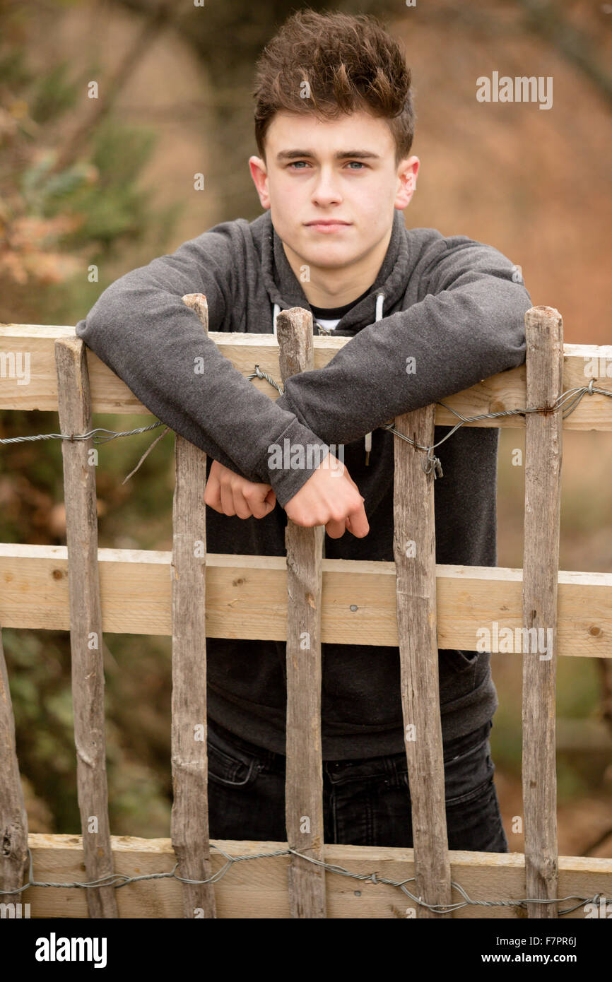 Teenager an einen Zaun gelehnt Stockfoto