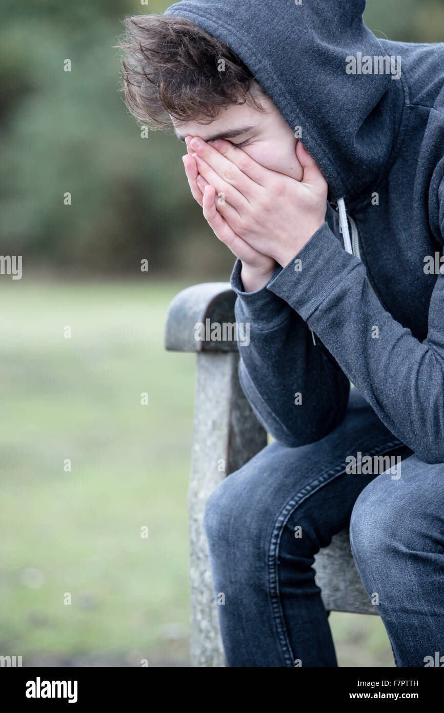 Traurige Teenager sitzen auf einer Parkbank Stockfoto