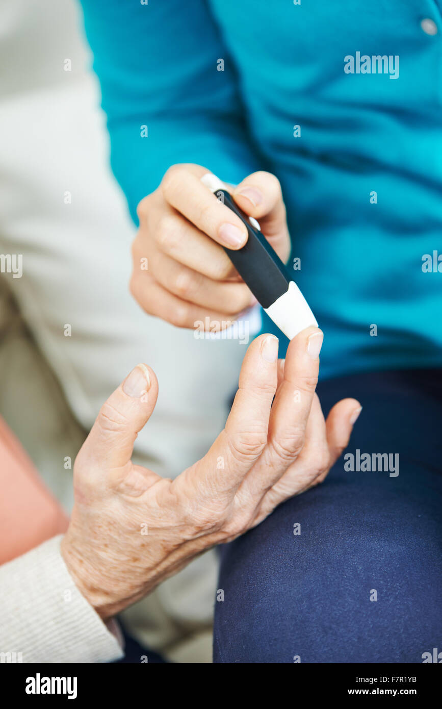 Blutzucker-monitoring für alte Frau an ihrem finger Stockfoto