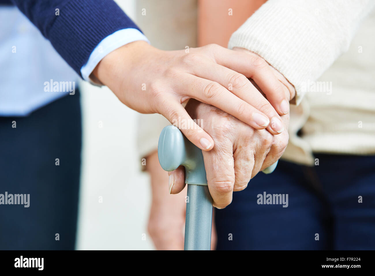Hand an Hand der älteren Frau mit dem Rohrstock Stockfoto