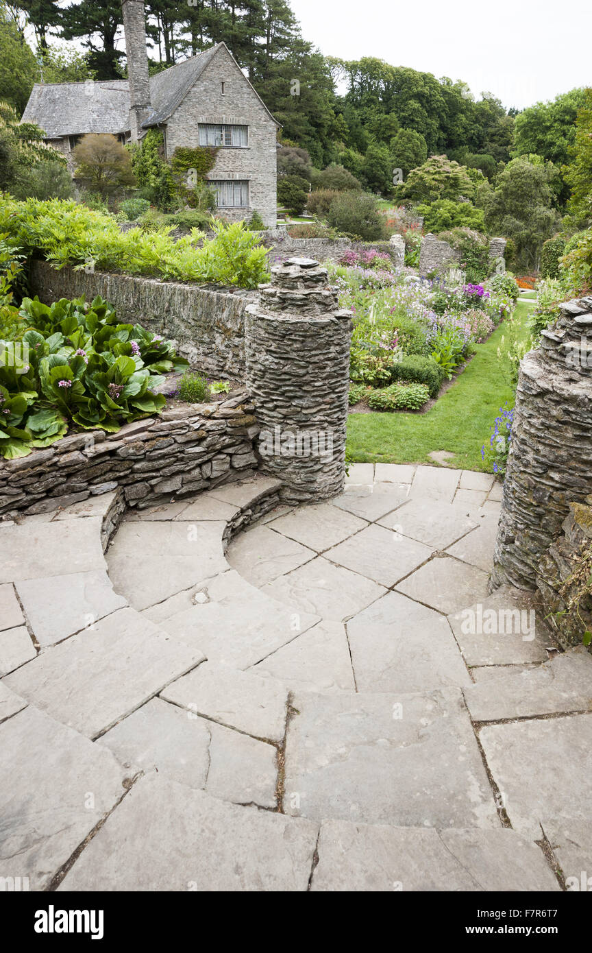 Geschwungene Treppe führt hinunter in den Garten Rill gepflanzt mit Pastell farbigen Blumen, bei Coleton Fishacre, Devon. Der Garten am Coleton Fishacre liegt in einem Tal, das Trommeln mit unterschiedlichen und exotischen Pflanzen hinunter zum Meer. Stockfoto