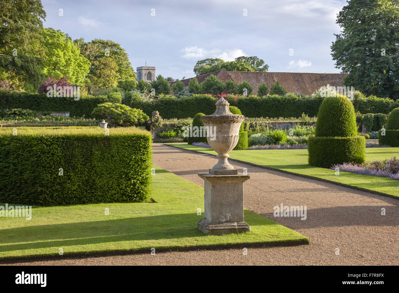 Der Garten, mit St Andrew Church im Hintergrund, Blickling Estate, Norfolk. Blickling ist ein Turm aus rotem Backstein jakobinischen Herrenhaus, sitzen in wunderschönen Gärten und Parks. Stockfoto