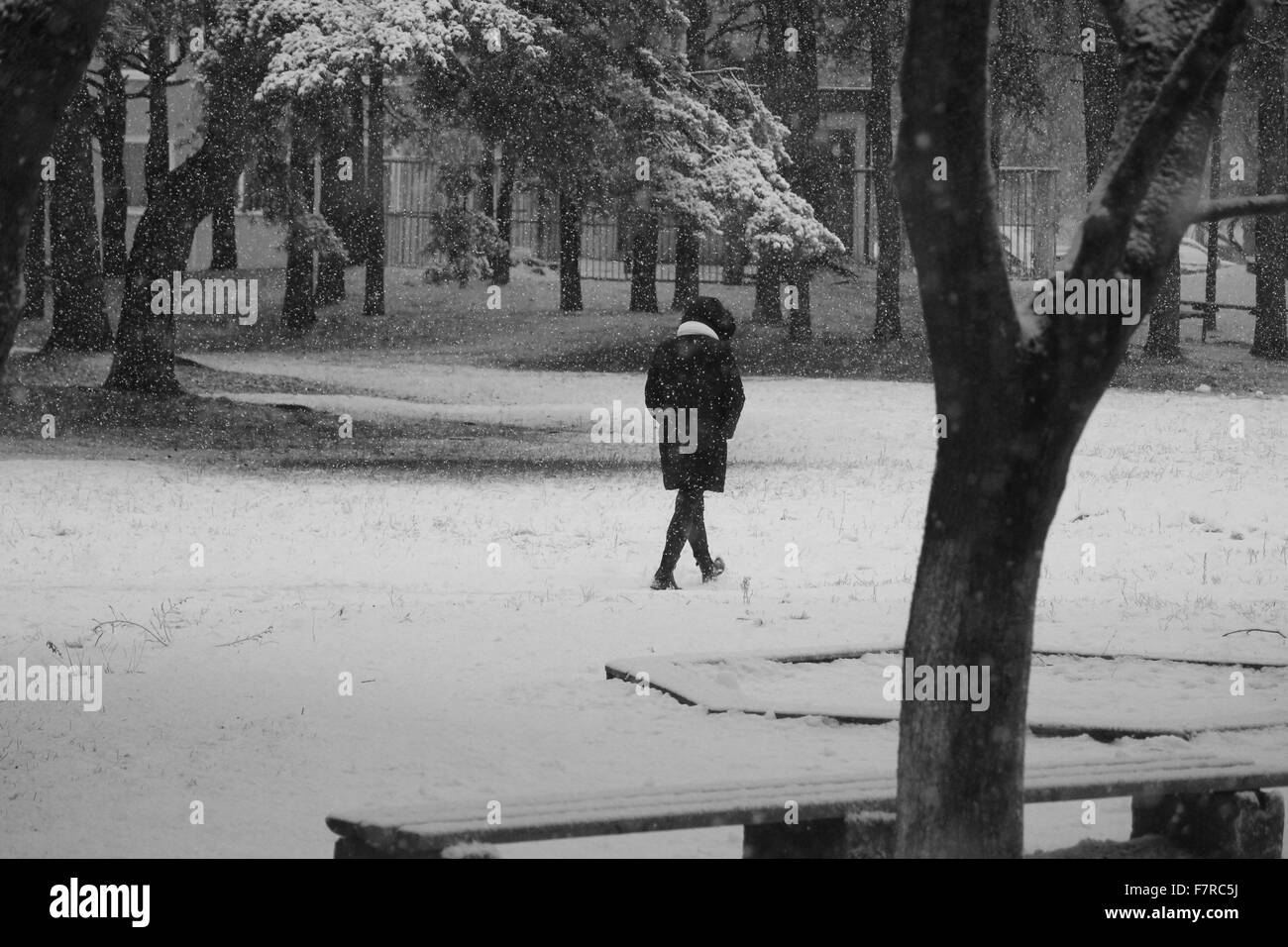 Figur des einsamen Spaziergang Frau auf tief verschneiten Straße Stockfoto