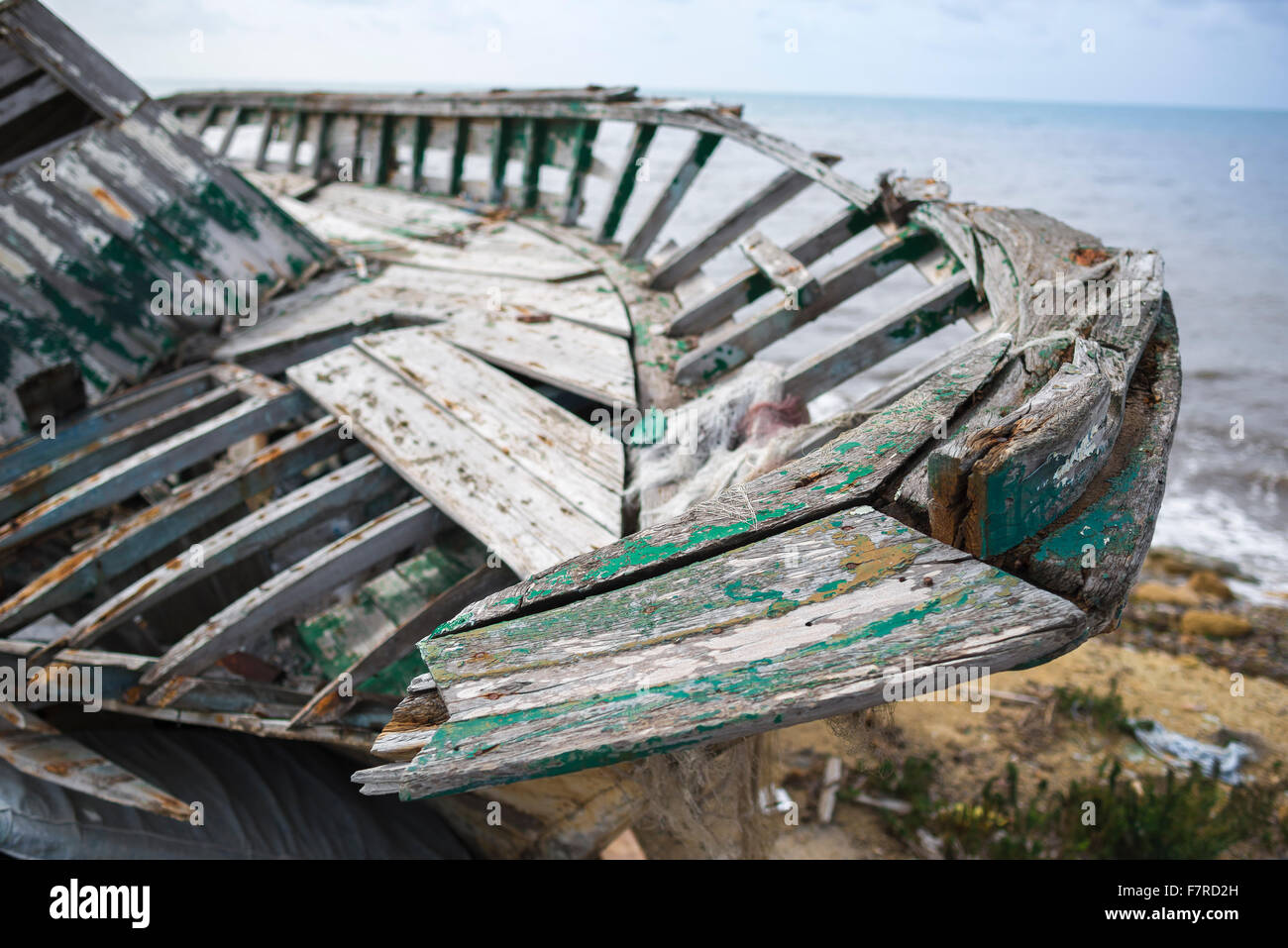 Verlassene boot Strand, Blick auf einem verlassenen Boot, mit dem Zerfall links neben dem Meer-Wand in Marsala, Sizilien. Stockfoto