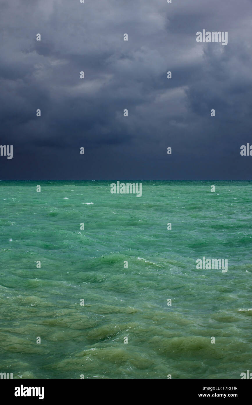 Dunkle Regenwolken über dem smaragdgrünen Meerwasser Stockfoto