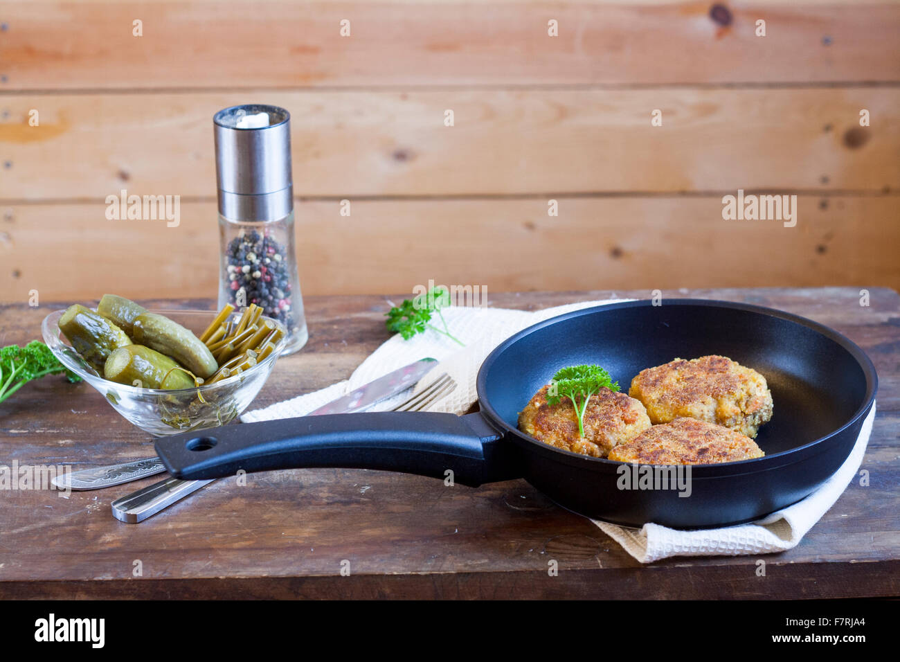 Burger (Schnitzel) In The Frying Pan. Burger (Schnitzel) in der Pfanne auf dem Holztisch Stockfoto