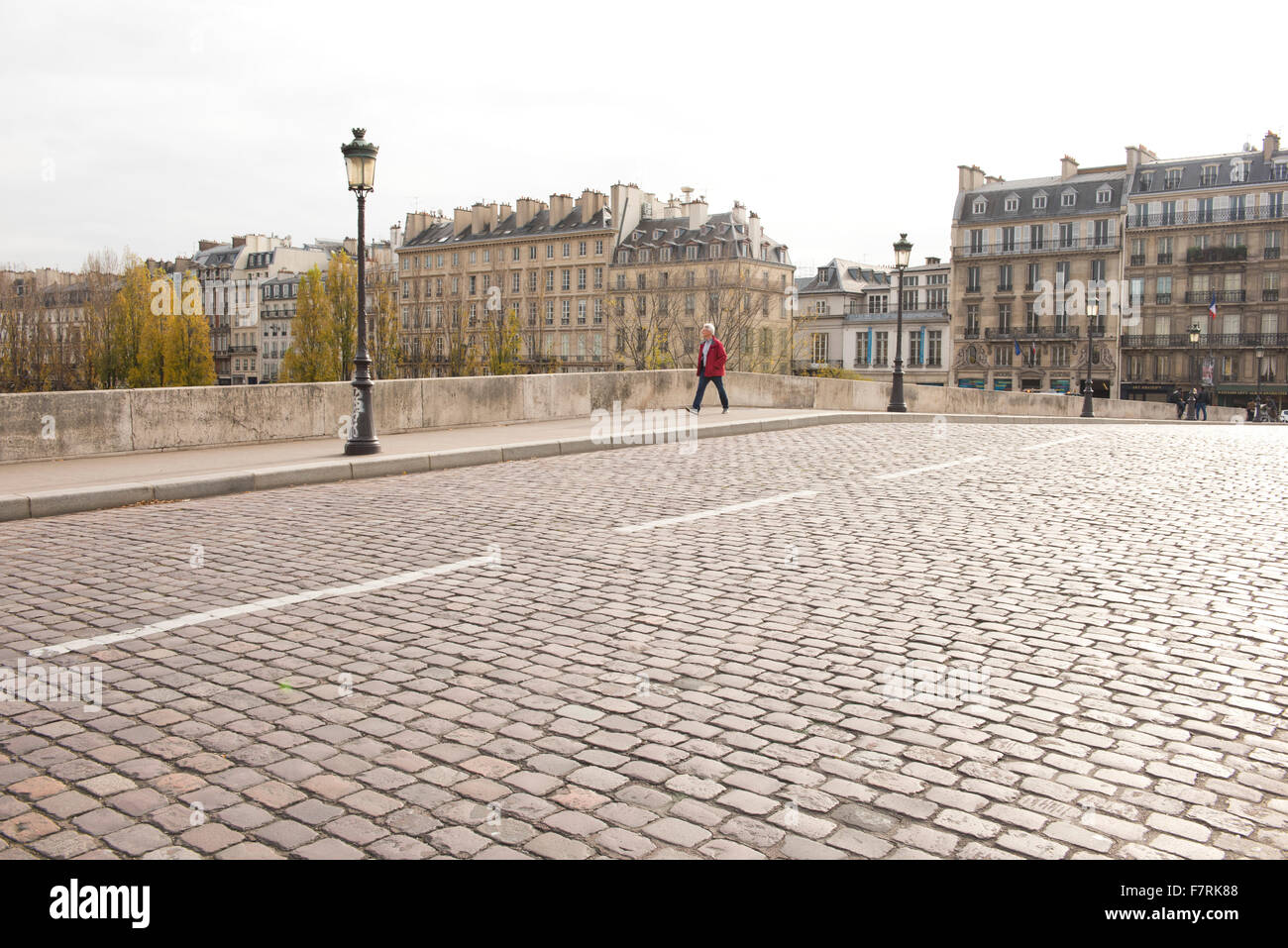 Ein Mann zu Fuß über die Kopfsteinpflaster Petit Pont Kardinal Lustiger und Quai de Montebello; Paris, Frankreich Stockfoto