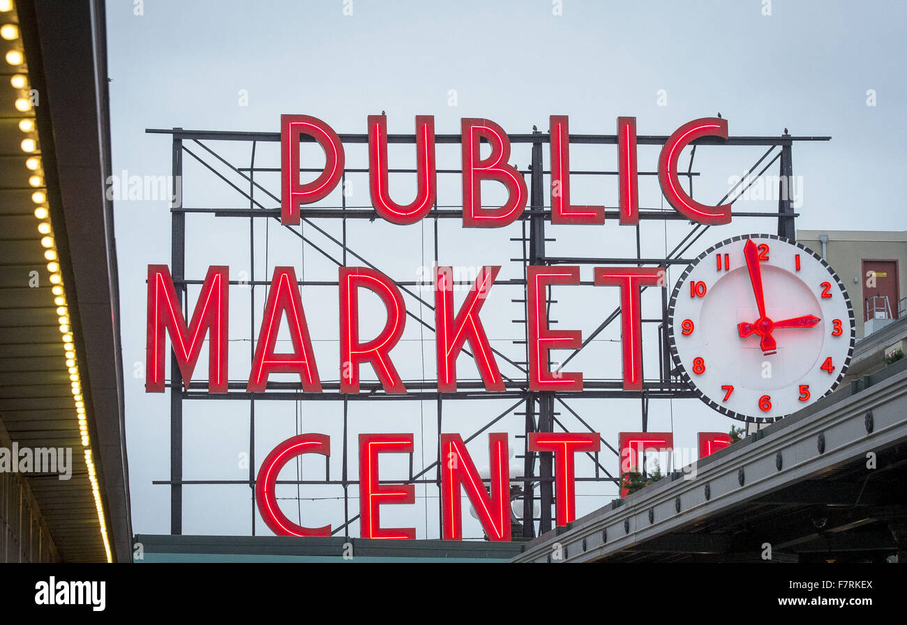 Seattle, Washington, USA. 23. November 2015. Pike Place Market in Seattle begann im Jahr 1907 und wurde entwickelt, um kleine Landwirte und Fischer sowie die Macher von anderen Gütern zu profitieren. Pike Place Market entlang der Waterfront Seattle entlang Elliott Bay gelegen und besteht aus nicht entlang Pike Place, einer Stadtstraße, aber auch mehrere Stockwerke unter sowie. Pike Place Market hat im Laufe der Jahre einige Veränderungen durchgemacht, aber behielt seinen Charme der alten Welt die Touristen aus der ganzen Welt. ---Auf dem Foto kündigt eine große Leuchtreklame neben einer großen Uhr Eingang zum Pike Place Market Stockfoto