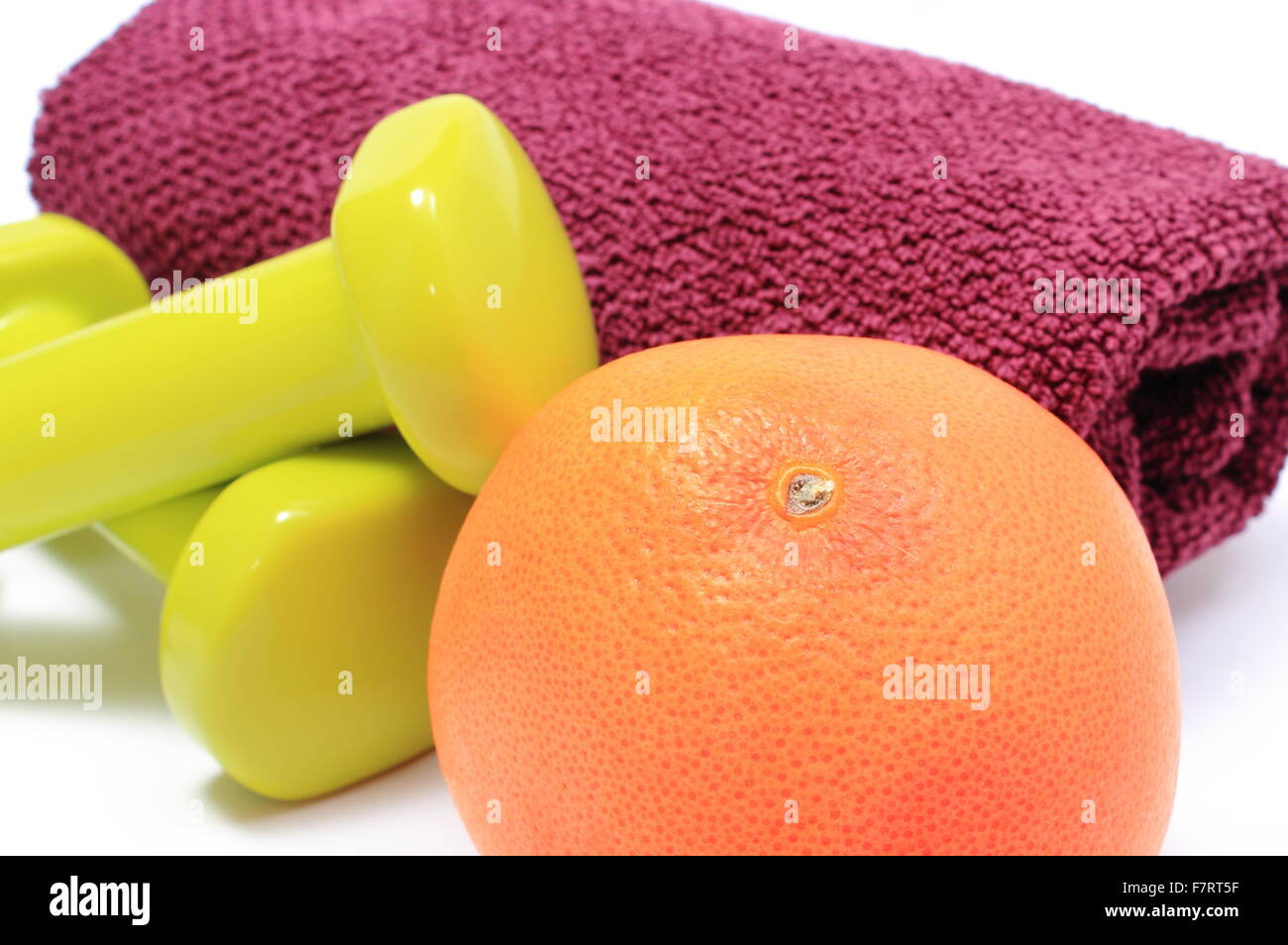 Grüne Hanteln, lila Handtuch für den Einsatz in Fitness und frische Grapefruit, Konzept für gesunde Ernährung und Lebensweise. Stockfoto