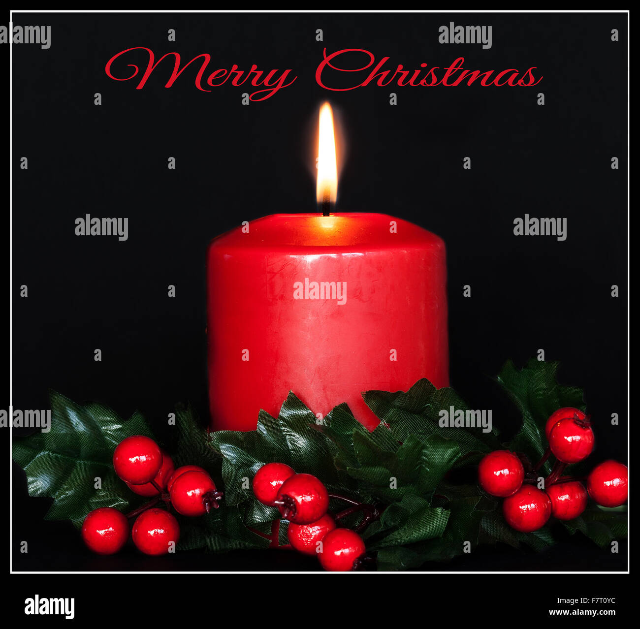 Roten Urlaub Kerze mit Holly Akzenten und Frohe Weihnachten text Stockfoto