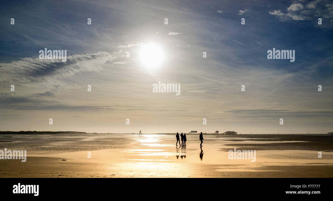 Spaziergänger am Strand bei Sonnenuntergang, Sankt Peter-Ording, Schleswig Holstein, Deutschland Stockfoto