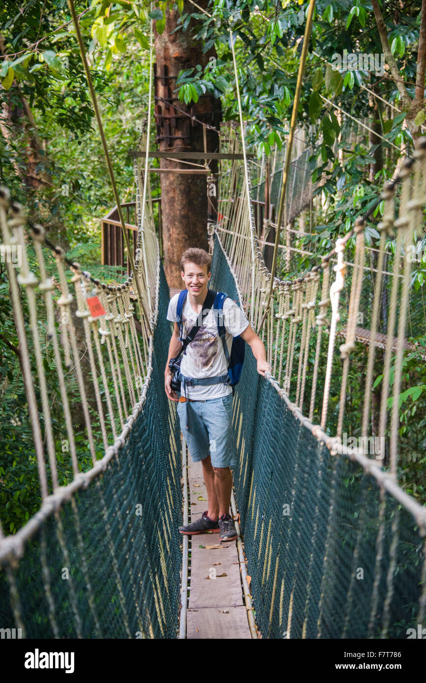 Junge männliche Touristen auf einer Hängebrücke in den Dschungel, Canopy Walkway, Kuala Tahan, Taman Negara Malaysia Stockfoto