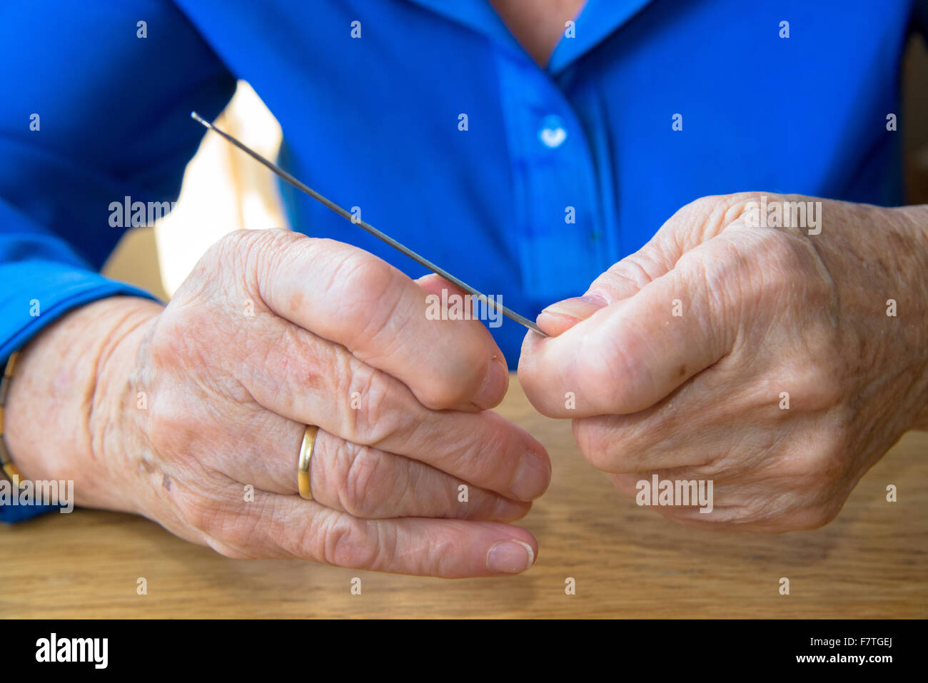 Händen der alten Frau Polieren der Nägel Stockfoto