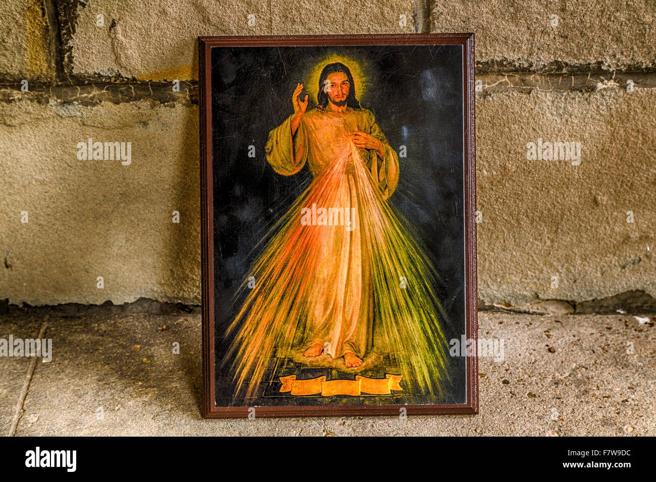 ein Symbol mit dem Bild des Barmherzigen Jesus stützte sich auf einer alten Mauer: die Multifunktionsleiste auf Unterseite ist leer Stockfoto