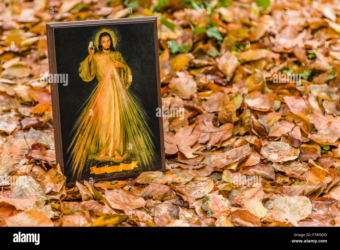 ein Symbol mit dem Bild des Barmherzigen Jesus stützte sich auf einer alten Mauer: die Multifunktionsleiste auf Unterseite ist leer Stockfoto