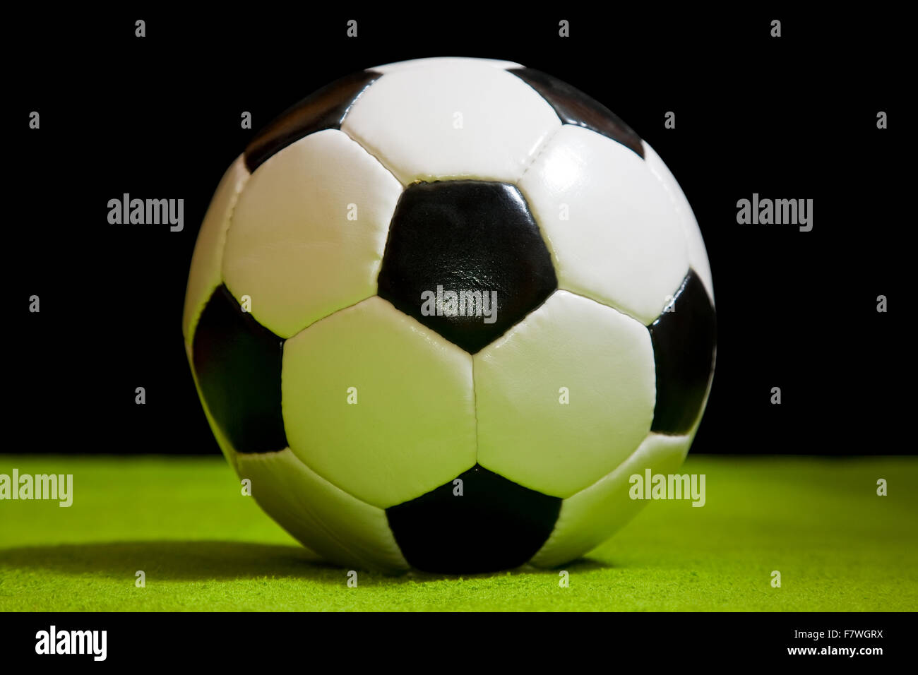 klassische Fußball auf Grün über schwarz Stockfoto