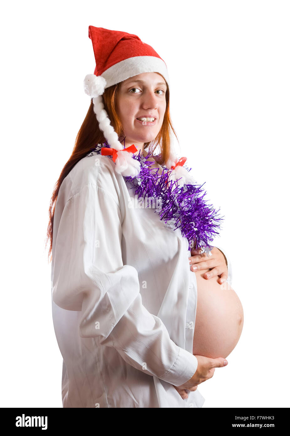 Schwangere Frau in Nikolausmütze über weiß Stockfoto