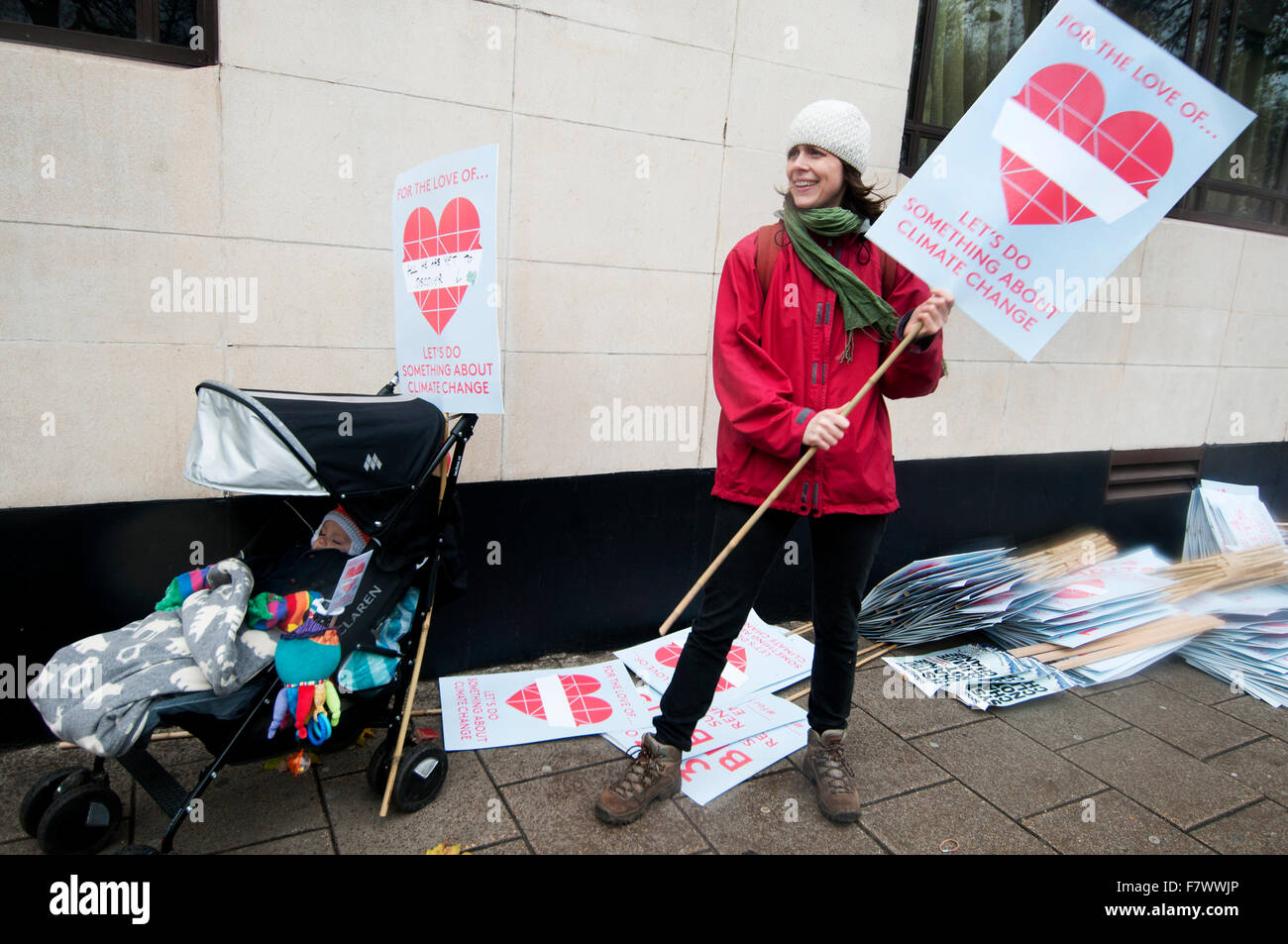 März auf Nachfrage Maßnahmen weltweite führenden zur Bekämpfung des Klimawandels. Eine Mutter mit ihrem Baby in einem Kinderwagen verteilt Plakate Stockfoto