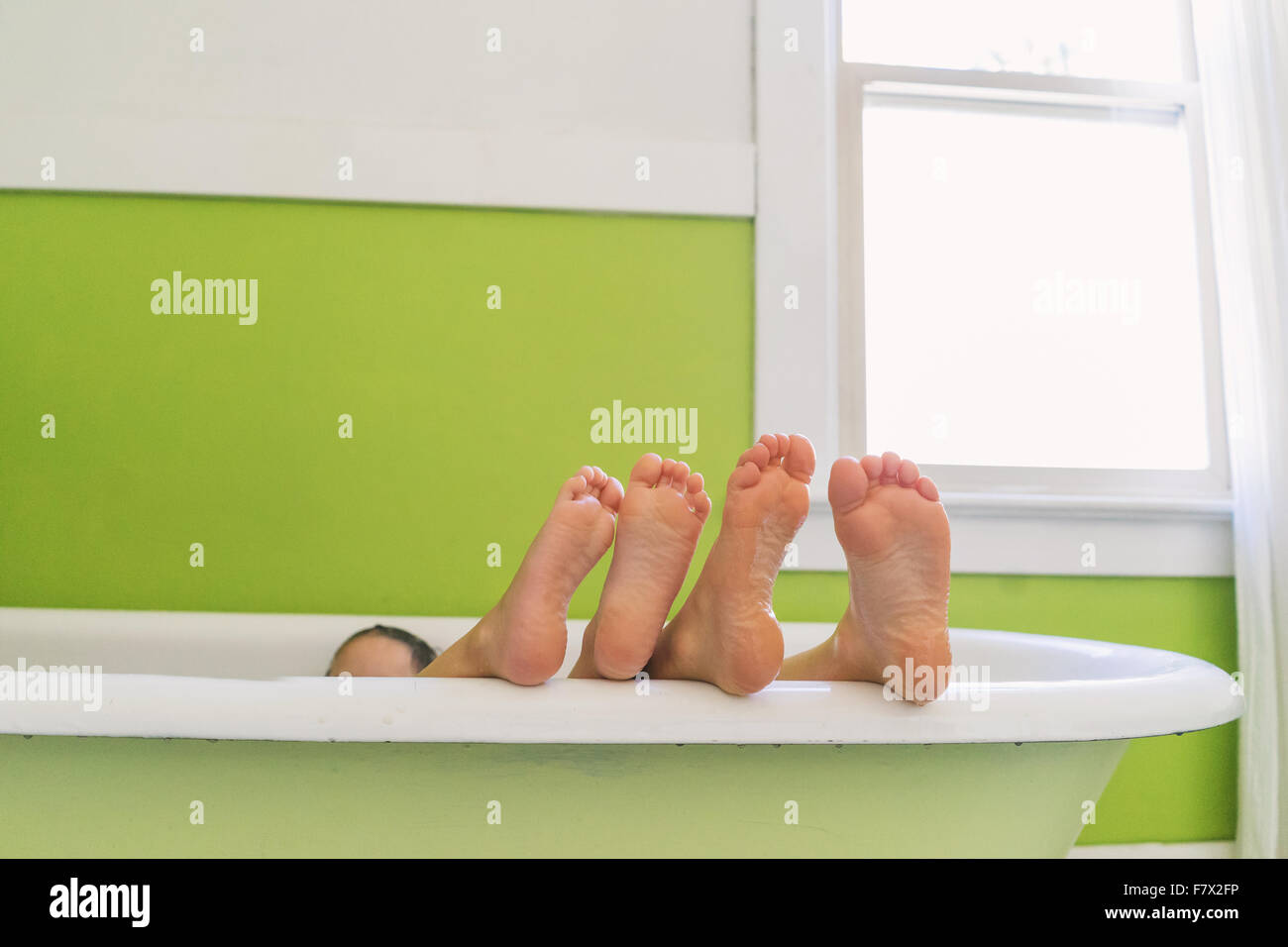 Füße von zwei Kindern in der Badewanne Stockfoto