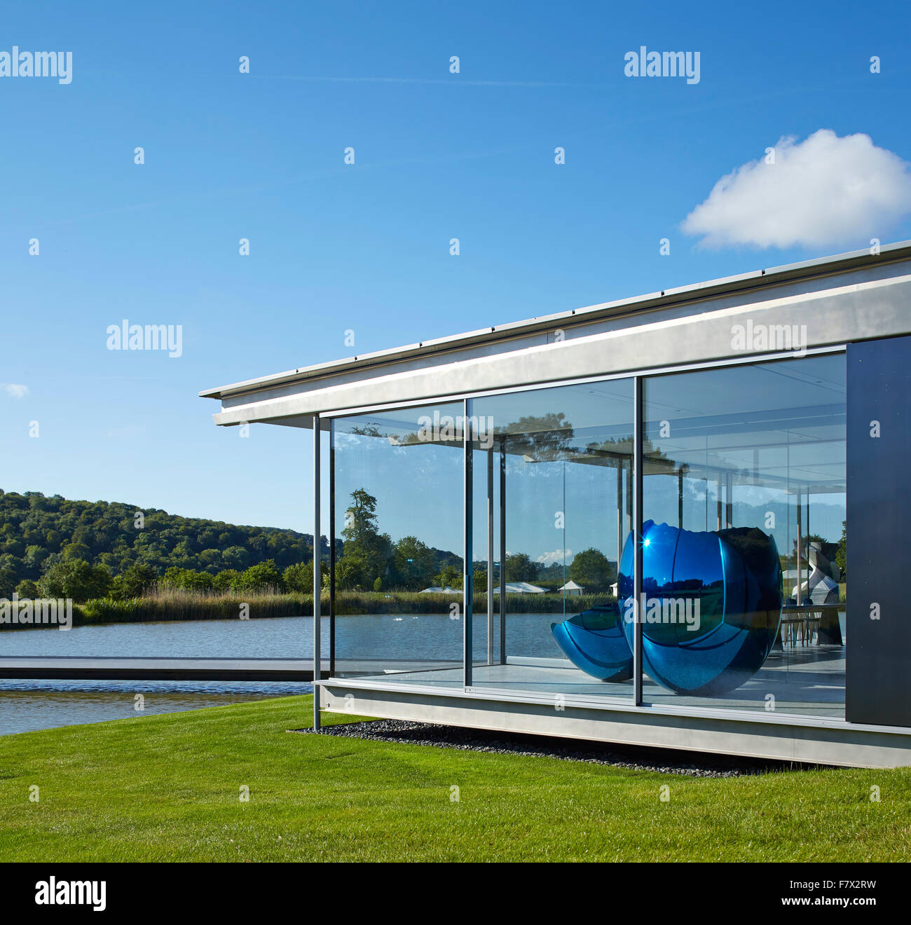 Seitenansicht mit See, Glaspavillon und Jeff Koons-Skulptur. Insel-Pavillon und Steg, High Wycombe, Vereinigtes Königreich. Stockfoto