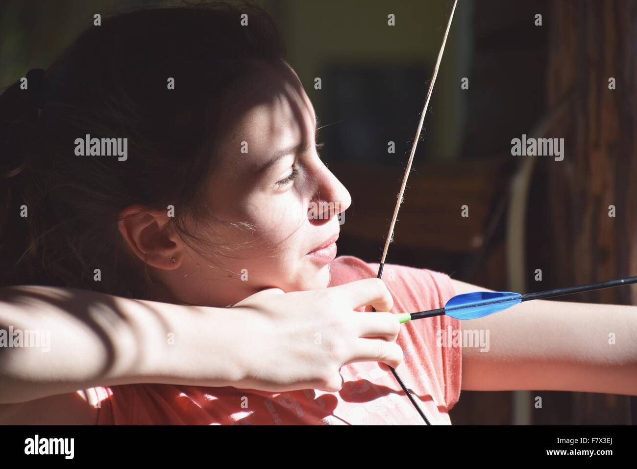 Porträt eines Mädchens, das einen Pfeil und Bogen schießt Stockfoto