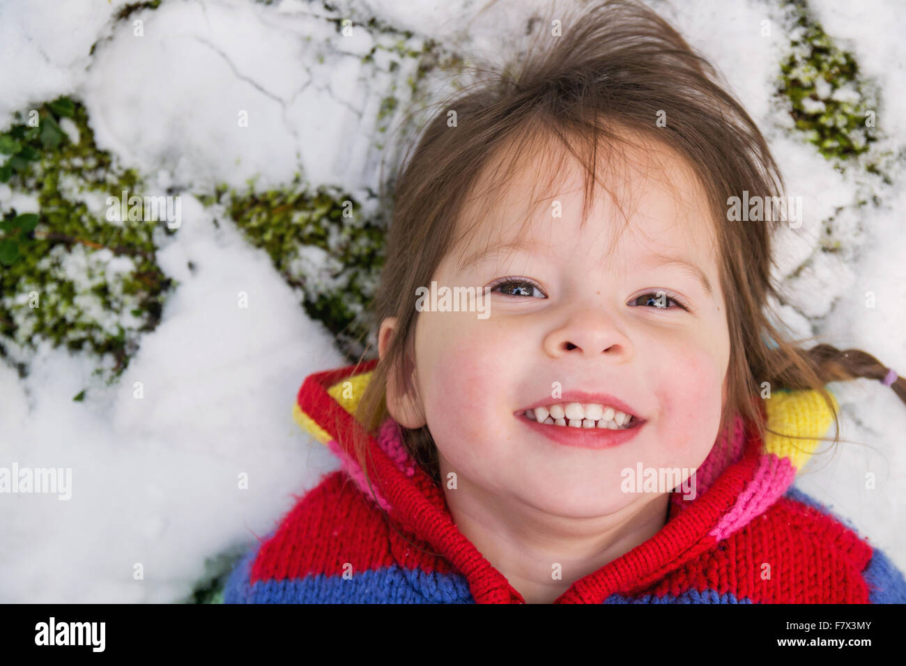 Porträt eines Mädchens im Schnee liegend Stockfoto